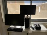 two monitors and a keyboard on a desk in front of a window