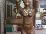 une statue représentant un homme tenant un pot sur la tête