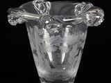 a clear glass vase with a handle on a black background