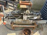 a machine that is sitting on the ground next to a bucket