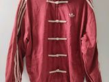 une veste rouge à rayures blanches suspendue à un cintre