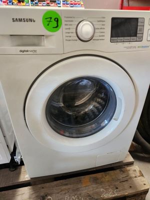 une machine à laver posée sur une palette dans un magasin