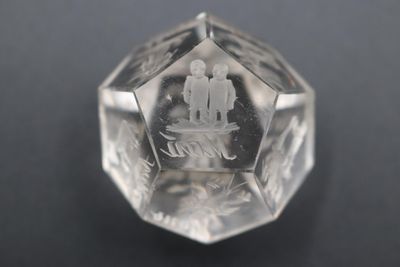 clear crystal cube with a couple on it on a black surface
