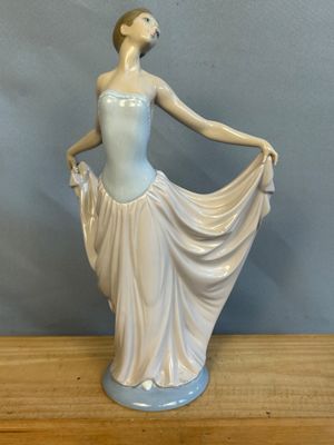 une figurine représentant une femme en robe, posée sur une table