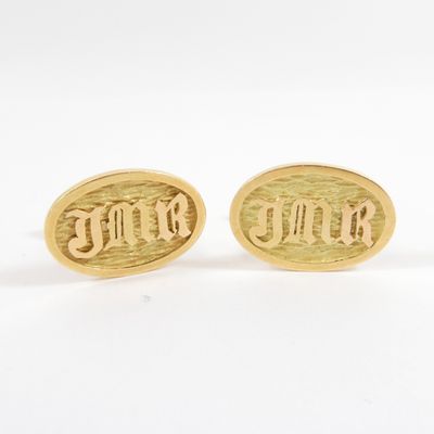 a pair of gold tone cufflinks with the word ' love ' engraved on them