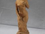 statue of a woman holding a flower in her right hand