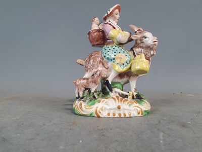 une figurine représentant une femme chevauchant une chèvre
