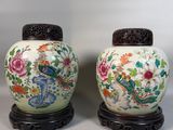 pair of chinese vases on stands with flowers and birds on them