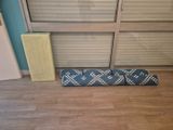 un tapis bleu et blanc posé sur le sol, à côté d'une porte-fenêtre coulissante