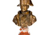 statue représentant le buste d'un homme coiffé d'un chapeau, posée sur un socle en marbre
