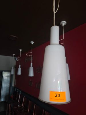 une lampe blanche suspendue au plafond d'un restaurant