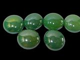 six green glass spheres are arranged in a row on a black background