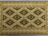 un gros plan d'un tapis marron et doré posé sur une surface blanche