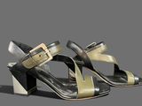 the woman ' s shoes are black and gold on a gray background