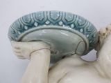 a statue of a child holding a bowl on his head
