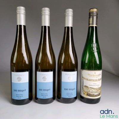quatre bouteilles de vin sont alignées sur une table