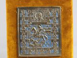 du velours jaune orné d'une plaque en métal argenté sur laquelle figure l'image d'un homme à cheval