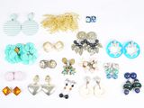 de nombreuses paires de boucles d'oreilles et de colliers posés sur un fond blanc