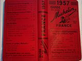 un livre ouvert, à la couverture rouge, posé sur une table