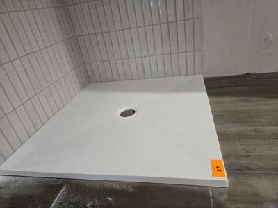 une photo d'une cabine de douche avec un sol en carrelage blanc