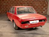 a red car that is parked in front of a brick wall