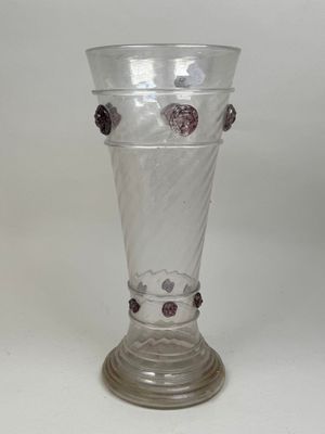a clear glass vase with purple flowers on it