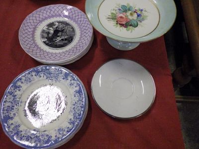 many plates and bowls on a table with a red table cloth