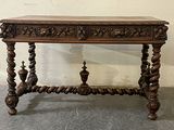 a wooden table with a carved top on the floor
