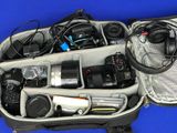 a bag filled with electronics and other items on a blue surface