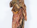 an old wooden statue of a man holding a book