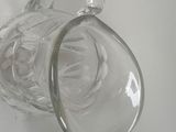 a glass pitcher hanging on a hook on a wall
