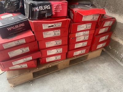 a pile of red boxes sitting on a pallet on the sidewalk