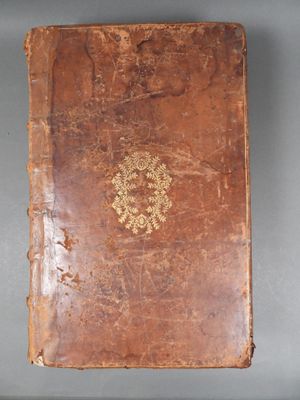 an old book sitting on top of a table on a gray surface
