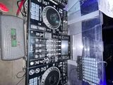 un homme debout à côté d'un imposant équipement de DJ