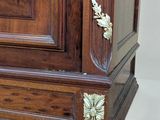 a wooden armoire with a clock on top of it
