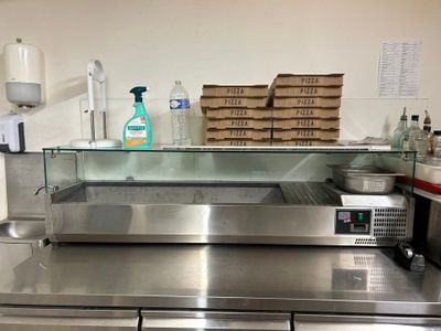 plan de travail en acier inoxydable dans une cuisine professionnelle équipée d'une vitrine en verre