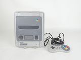 a nintendo classic game console with a controller next to it