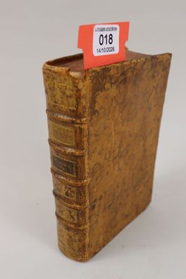 un vieux livre sur lequel est accrochée une étiquette rouge