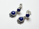 une paire de boucles d'oreilles ornées de pierres bleues sur fond blanc