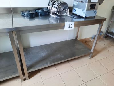 une table en acier inoxydable sur laquelle sont posés des plats, dans une cuisine