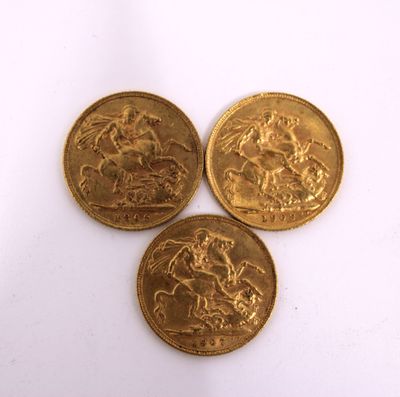 three gold coins sitting on top of each other on a white surface