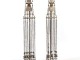 pair of silver and gold earrings with tassels on stands