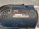 a close up of a corded drill on a table