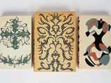 trois blocs en bois présentant des motifs différents, posés sur une surface blanche