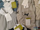 a lot of men ' s shirts that are on a bed
