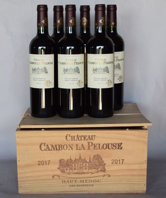 four bottles of wine are in a wooden box on a table