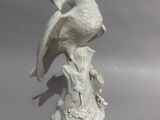 porcelain figurine of a bird perched on a tree stump