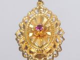pendentif en or jaune orné d'une pierre rose en son centre