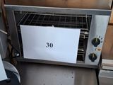 a toaster oven sitting on a table with a sign on it