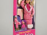 La poupée Barbie se trouve dans une boîte rose posée sur une surface blanche.